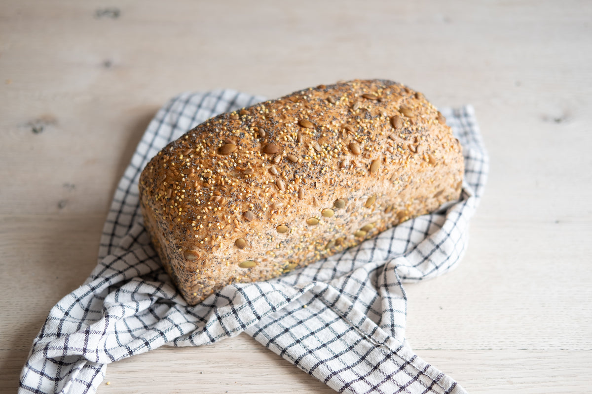 Loaf of bread on a checkered cloth with a wooden background